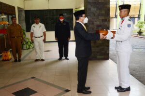 Walikota Metro Menyerahkan Bendera Merah Putih Kepada Paskibraka Kota Metro