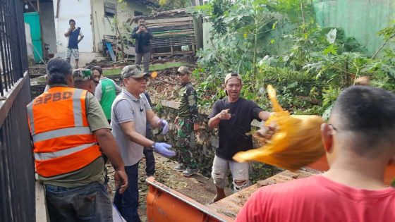 Menyatu dengan warga, Wali Kota dan Wakil Wali Kota Metro bersihkan puing pagar yang ambruk karena hujan deras